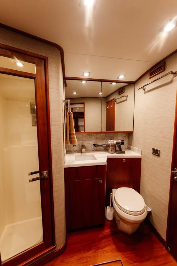 The yacht's bathroom features elegant wood finishes and modern amenities. aboard NEVER SAY NEVER Yacht for Sale