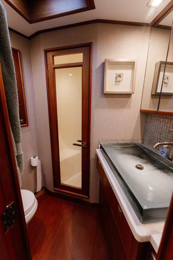 The yacht's bathroom features elegant wood finishes and a modern sink. aboard NEVER SAY NEVER Yacht for Sale