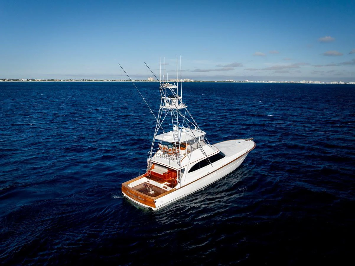 A sleek yacht cruises on open waters under a clear blue sky. aboard NEVER SAY NEVER Yacht for Sale