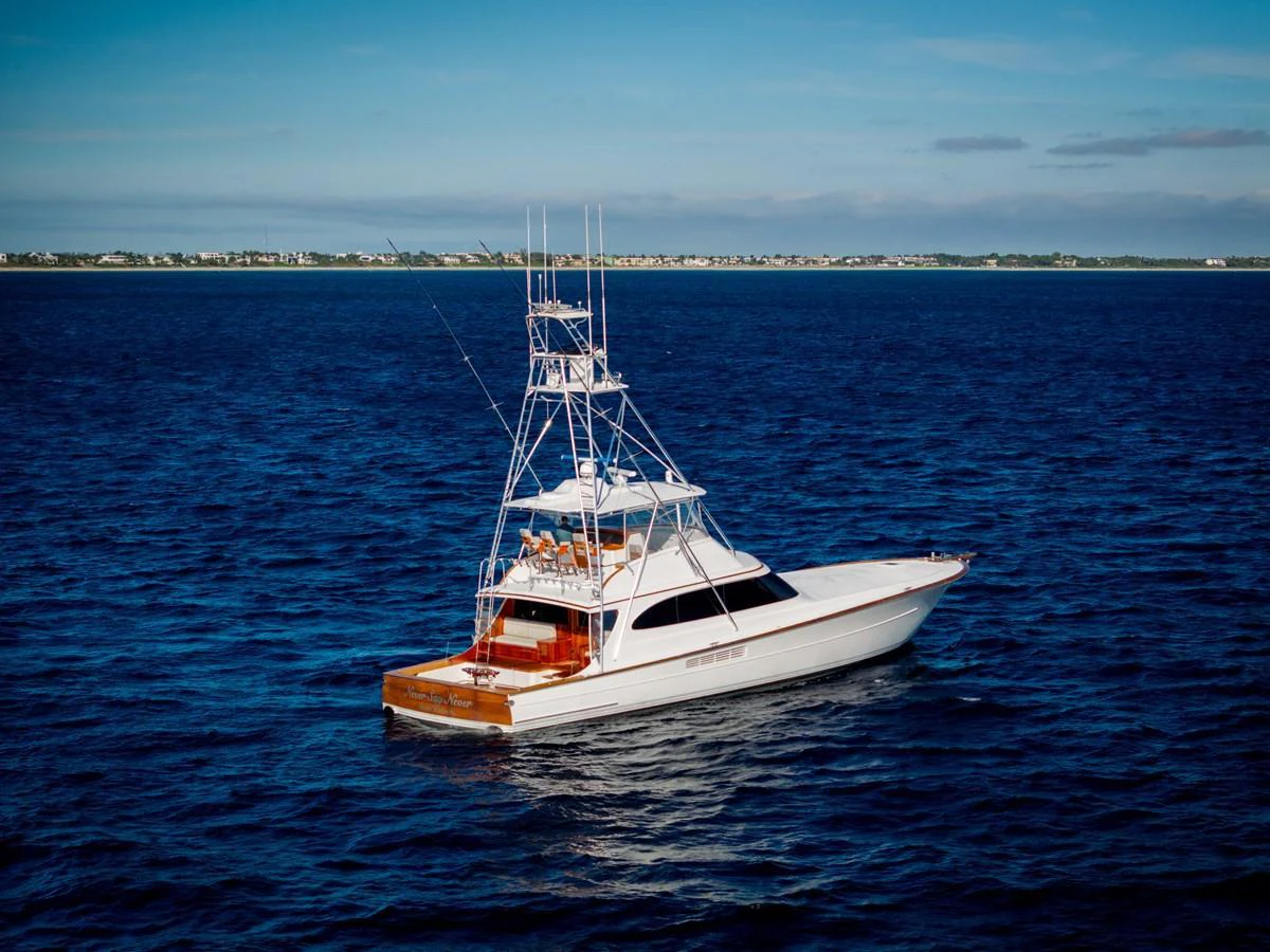 A sleek yacht cruises through deep blue waters under a clear sky. aboard NEVER SAY NEVER Yacht for Sale