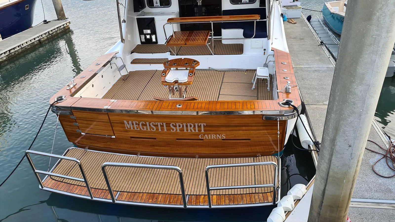 The yacht's aft deck features a spacious and inviting area with elegant wooden flooring and comfortable seating. aboard MEGISTI SPIRIT Yacht for Sale