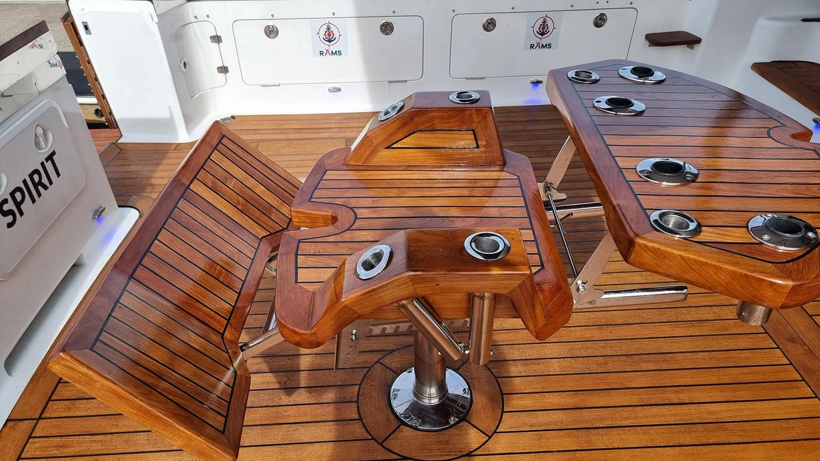 The aft deck features a beautifully crafted wooden table with integrated cup holders and seating. aboard MEGISTI SPIRIT Yacht for Sale