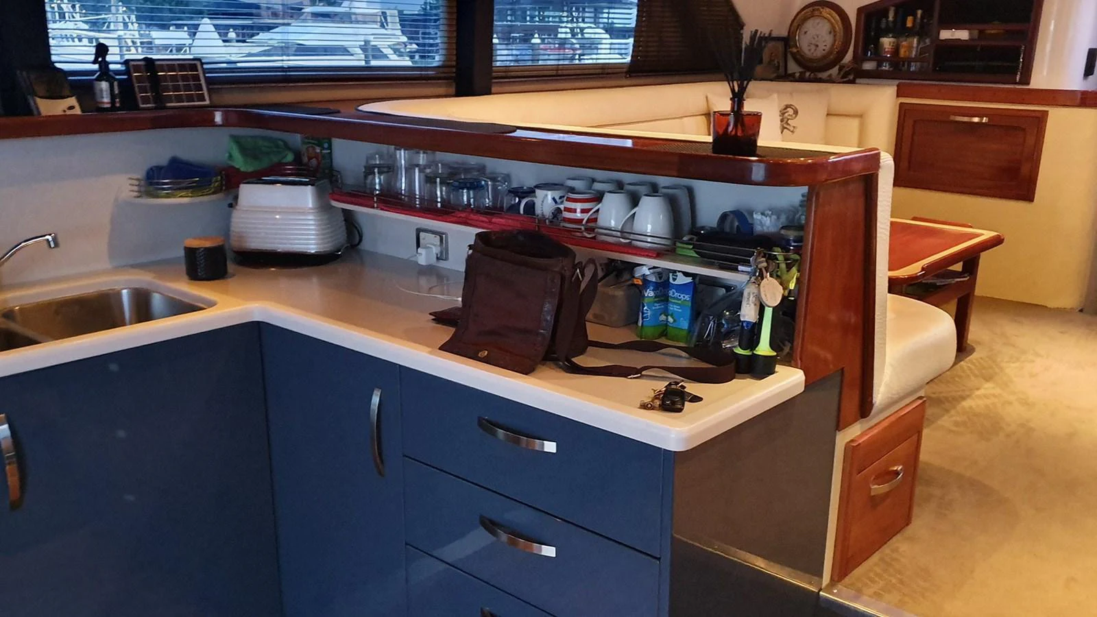 The yacht's galley features modern cabinetry, a sink, and ample counter space with a cozy dining area nearby. aboard MEGISTI SPIRIT Yacht for Sale