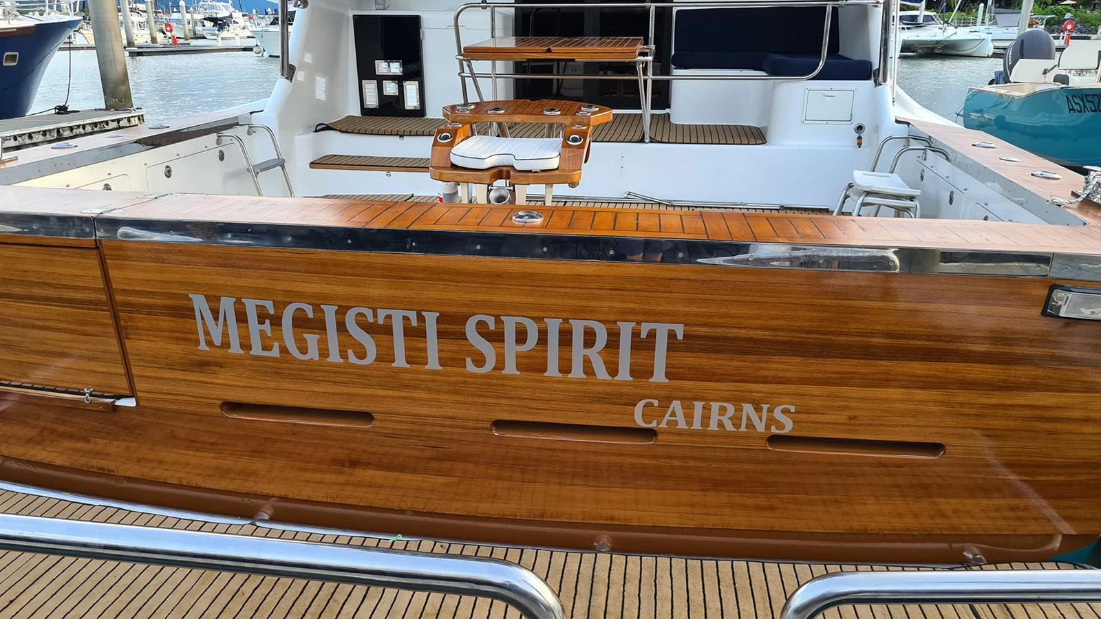 The aft deck of the yacht features a beautifully finished wooden transom with the yacht's name prominently displayed. aboard MEGISTI SPIRIT Yacht for Sale