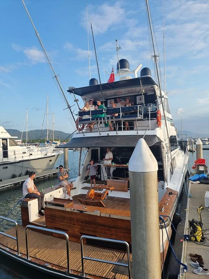 The yacht's aft deck is bustling with people enjoying the marina view. aboard MEGISTI SPIRIT Yacht for Sale