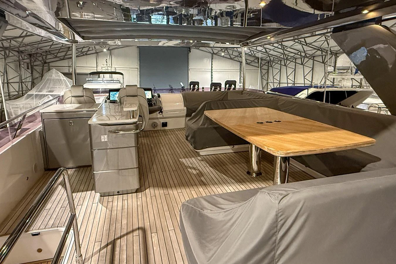 The aft deck features a spacious seating area with a wooden table and modern amenities. aboard PRINCESS 70 Yacht for Sale