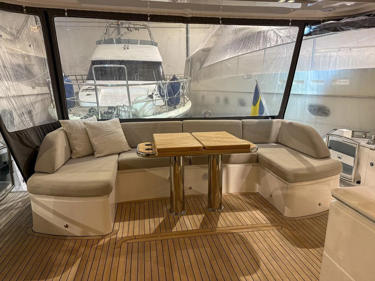 The aft deck features a cozy seating area with a wooden table, perfect for relaxation and socializing. aboard PRINCESS 70 Yacht for Sale
