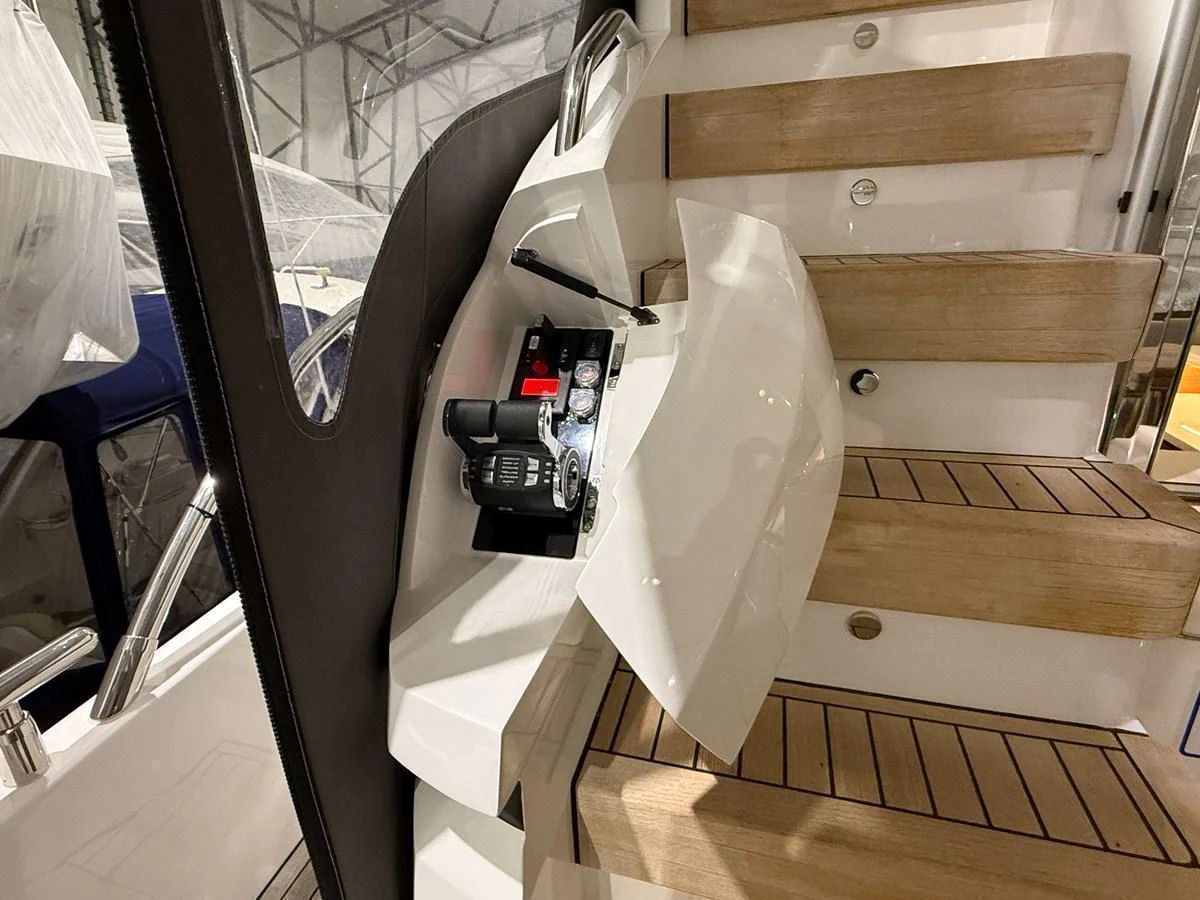A close-up of a yacht's staircase with wooden steps and a control panel. aboard PRINCESS 70 Yacht for Sale