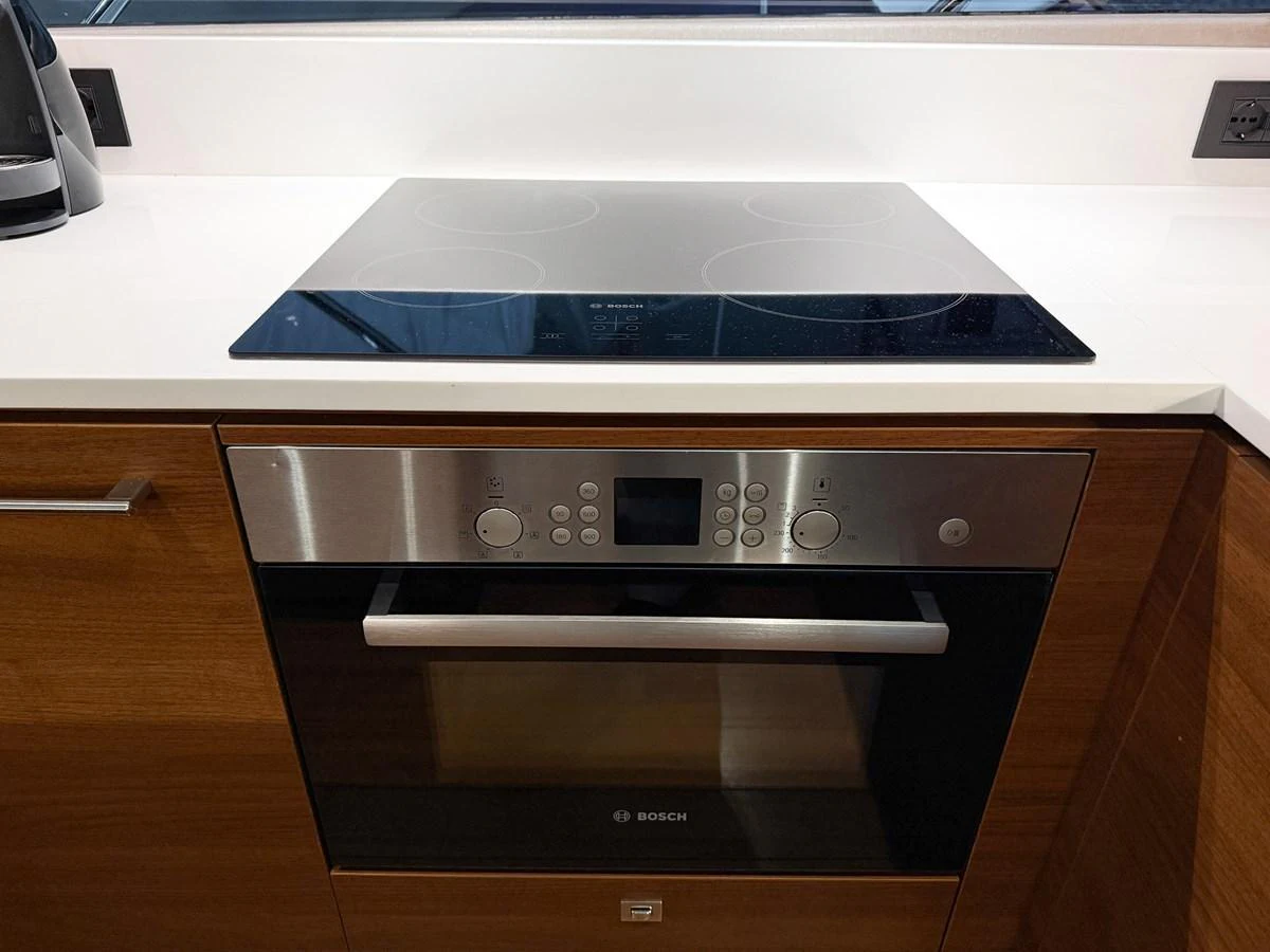 The yacht's galley features a modern stovetop and oven, perfect for gourmet cooking at sea. aboard PRINCESS 70 Yacht for Sale