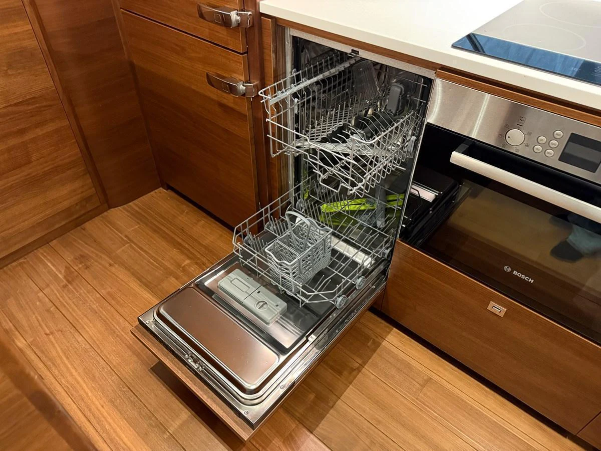 The yacht's galley features a modern dishwasher integrated into the cabinetry. aboard PRINCESS 70 Yacht for Sale