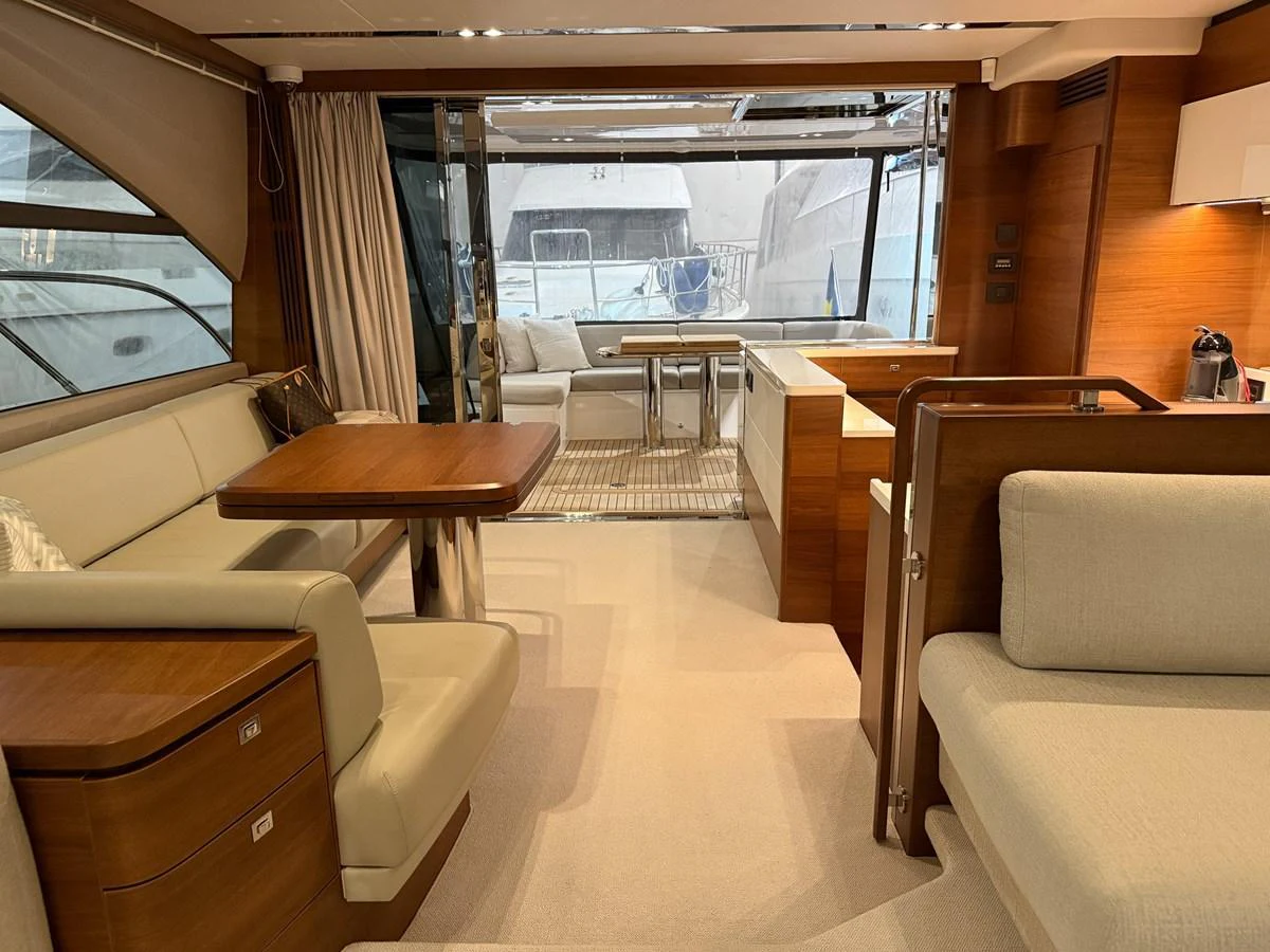 The yacht's salon features elegant seating and a dining area with a view of the aft deck. aboard PRINCESS 70 Yacht for Sale