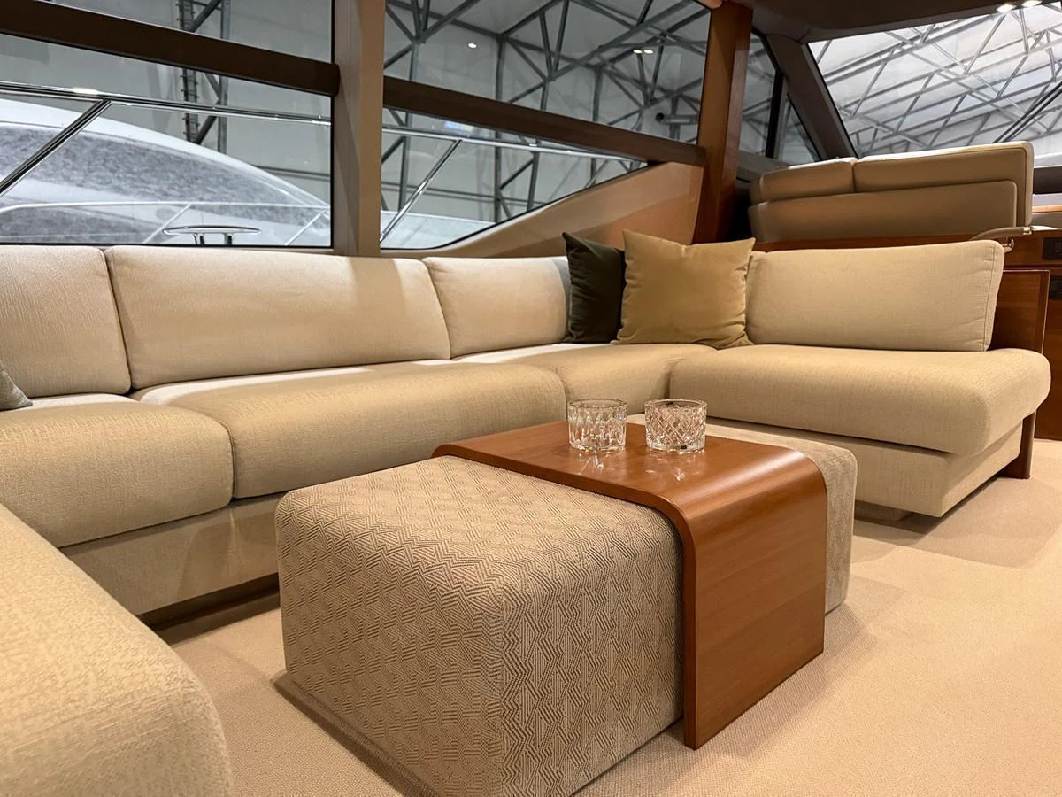 The salon features a luxurious seating area with plush cushions and a stylish wooden coffee table. aboard PRINCESS 70 Yacht for Sale