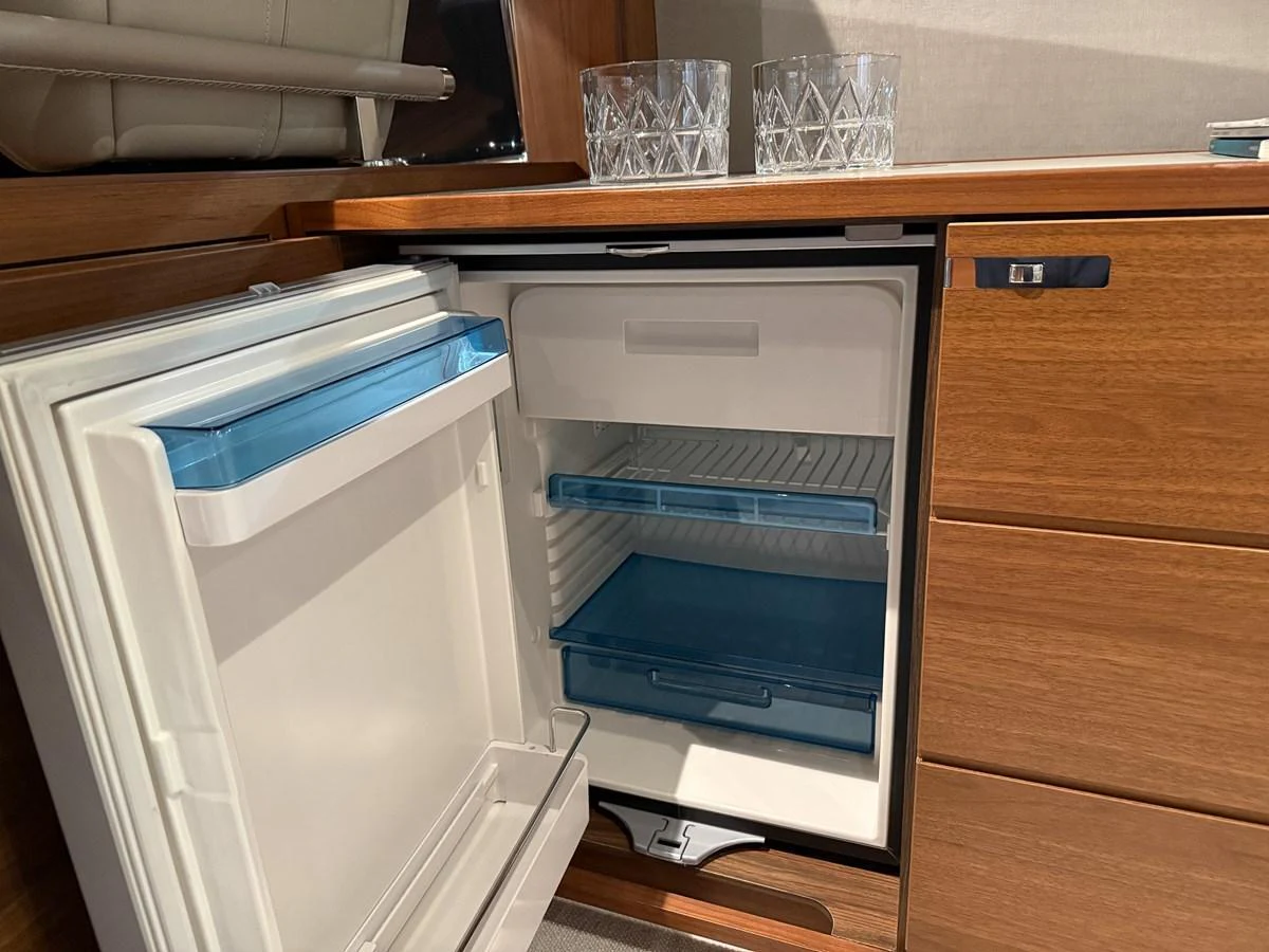 A compact refrigerator is built into the wooden cabinetry of the yacht's interior. aboard PRINCESS 70 Yacht for Sale