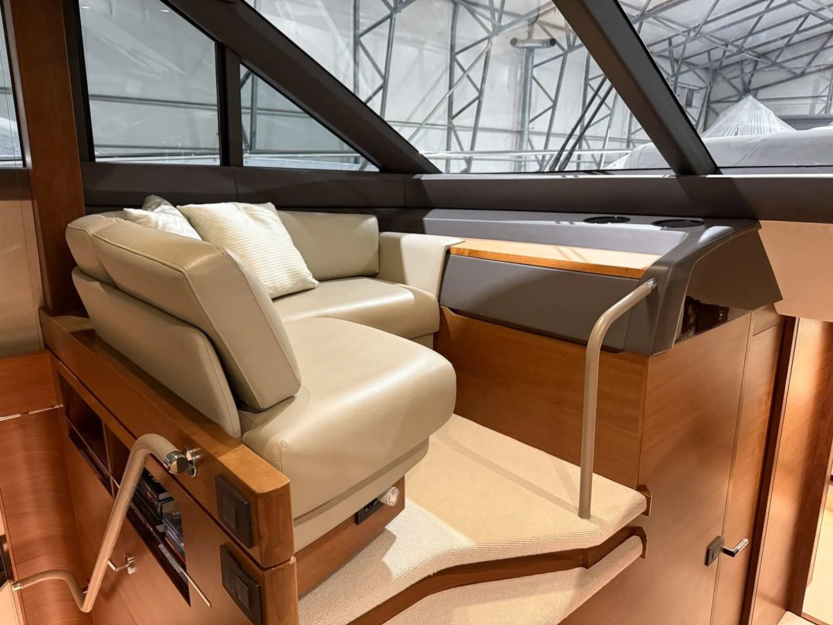 The yacht's interior features a cozy seating area with plush cushions and modern design elements. aboard PRINCESS 70 Yacht for Sale