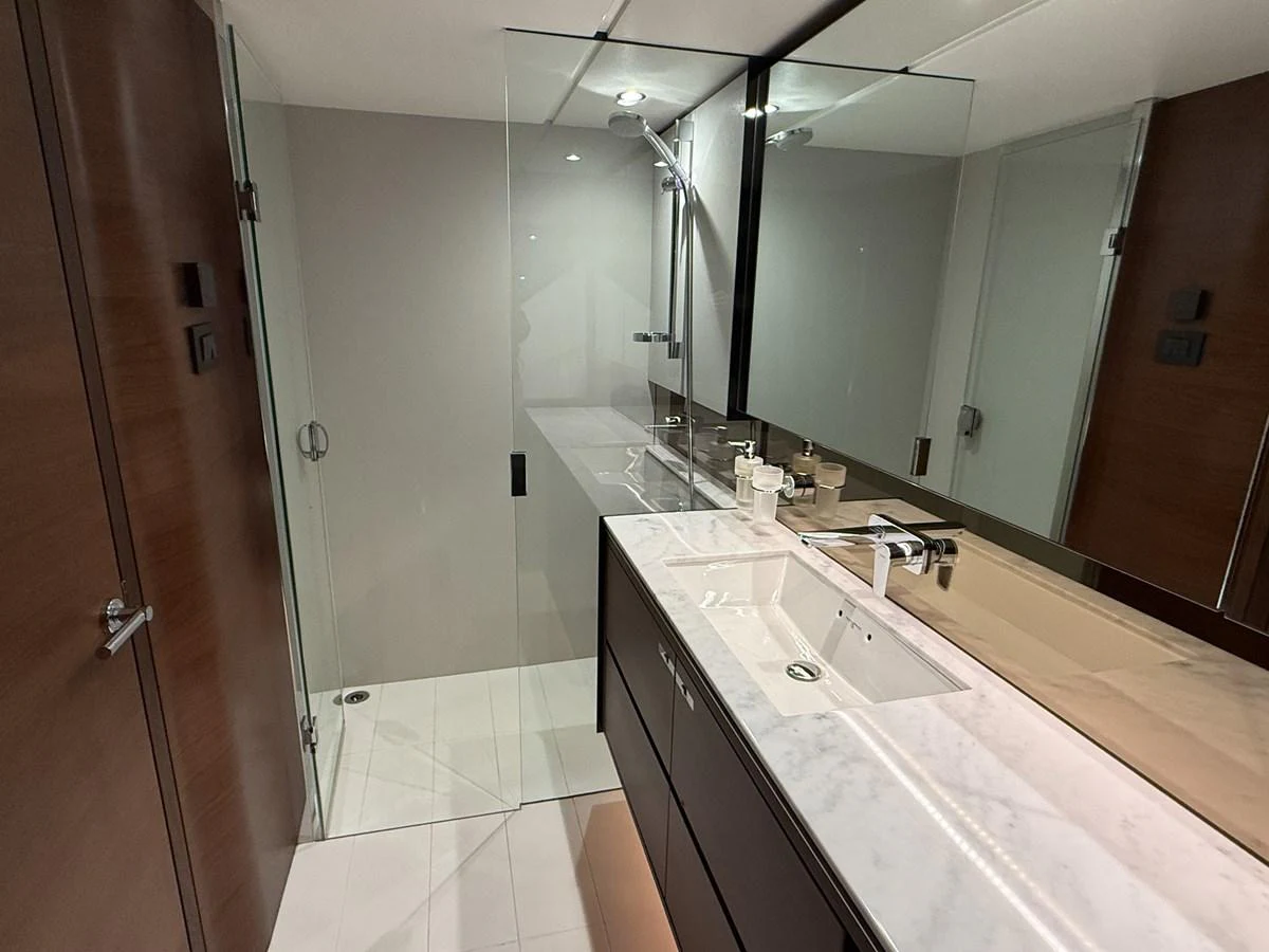 The yacht's bathroom features a sleek design with a glass-enclosed shower and a modern vanity. aboard PRINCESS 70 Yacht for Sale