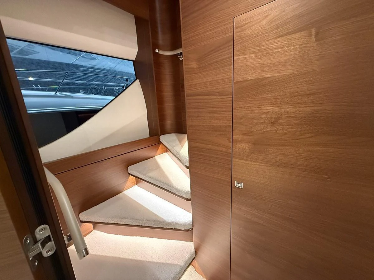 A cozy interior stairway with wooden paneling and carpeted steps. aboard PRINCESS 70 Yacht for Sale