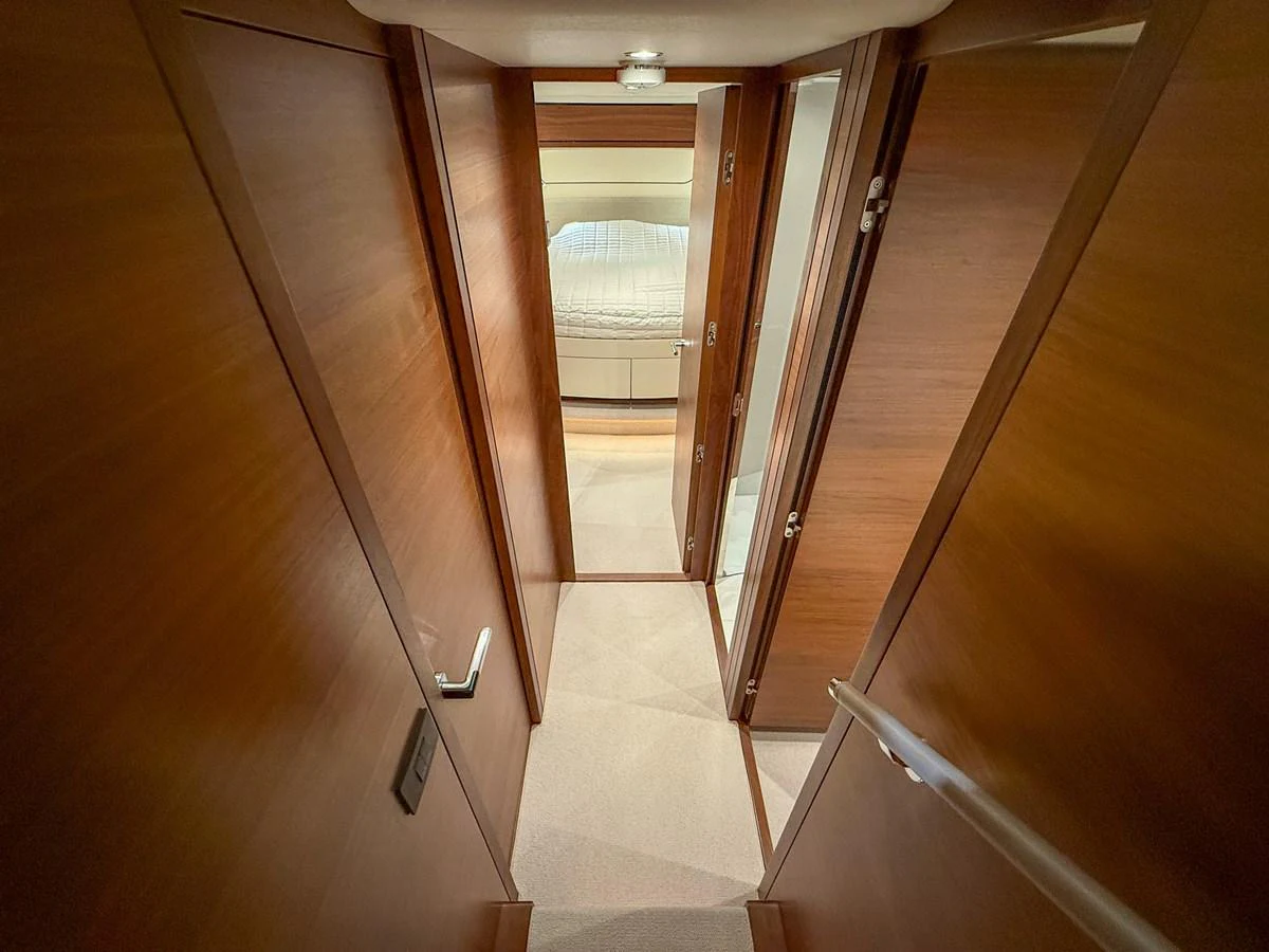 A cozy hallway leading to a well-appointed stateroom with warm wooden finishes. aboard PRINCESS 70 Yacht for Sale