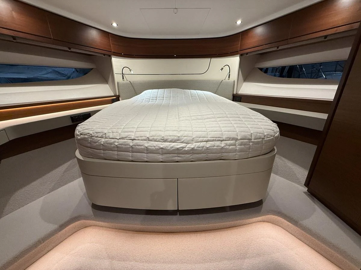 The master stateroom features a spacious bed with elegant wood accents and ambient lighting. aboard PRINCESS 70 Yacht for Sale