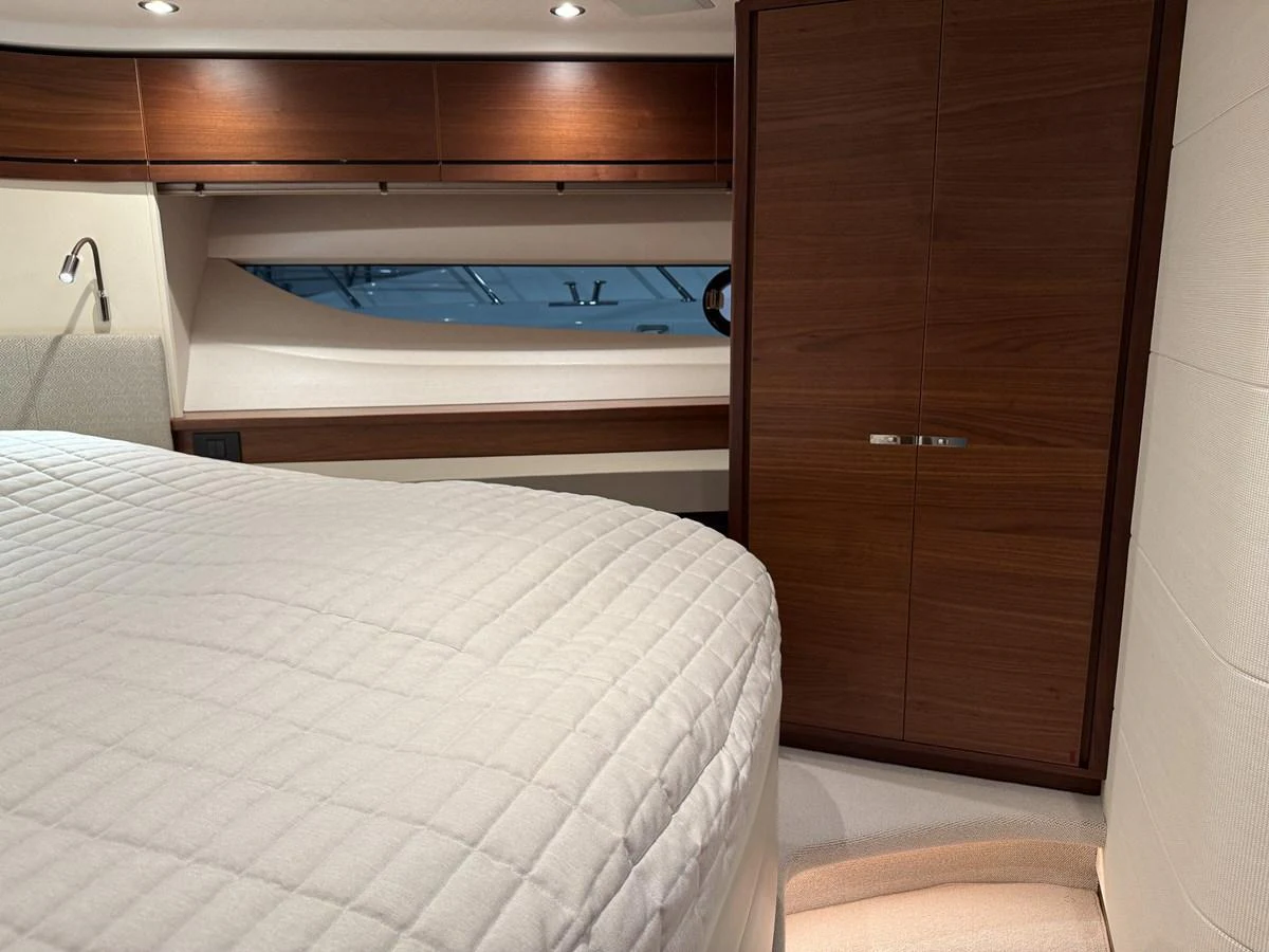 The stateroom features a cozy bed with elegant wood paneling and ample storage space. aboard PRINCESS 70 Yacht for Sale
