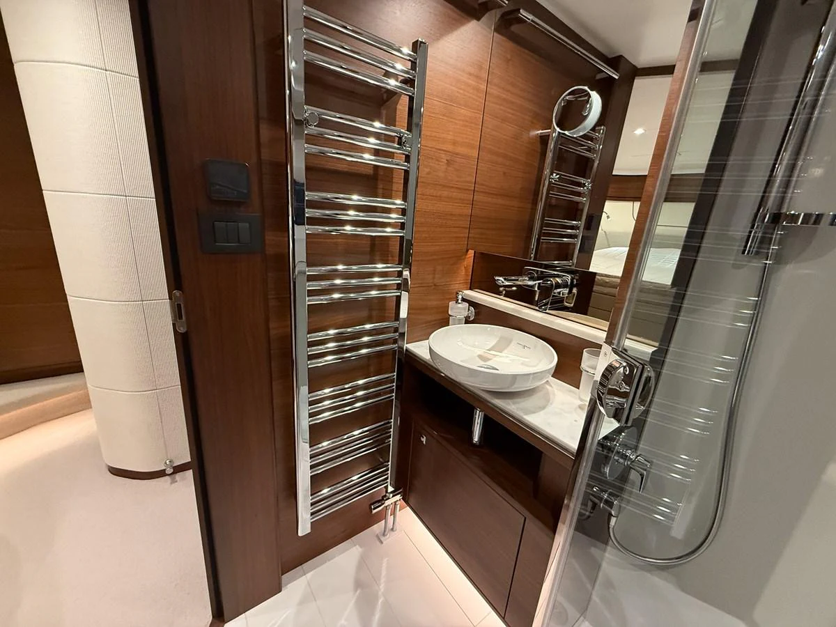 The yacht's bathroom features modern fixtures and a sleek design with rich wood accents. aboard PRINCESS 70 Yacht for Sale
