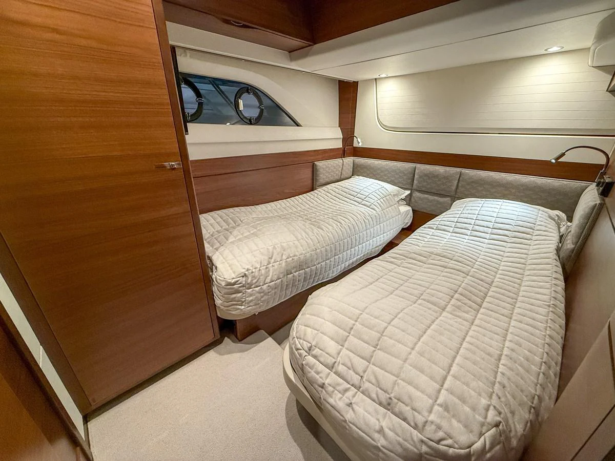 The twin stateroom features two comfortable single beds with a modern and cozy design. aboard PRINCESS 70 Yacht for Sale