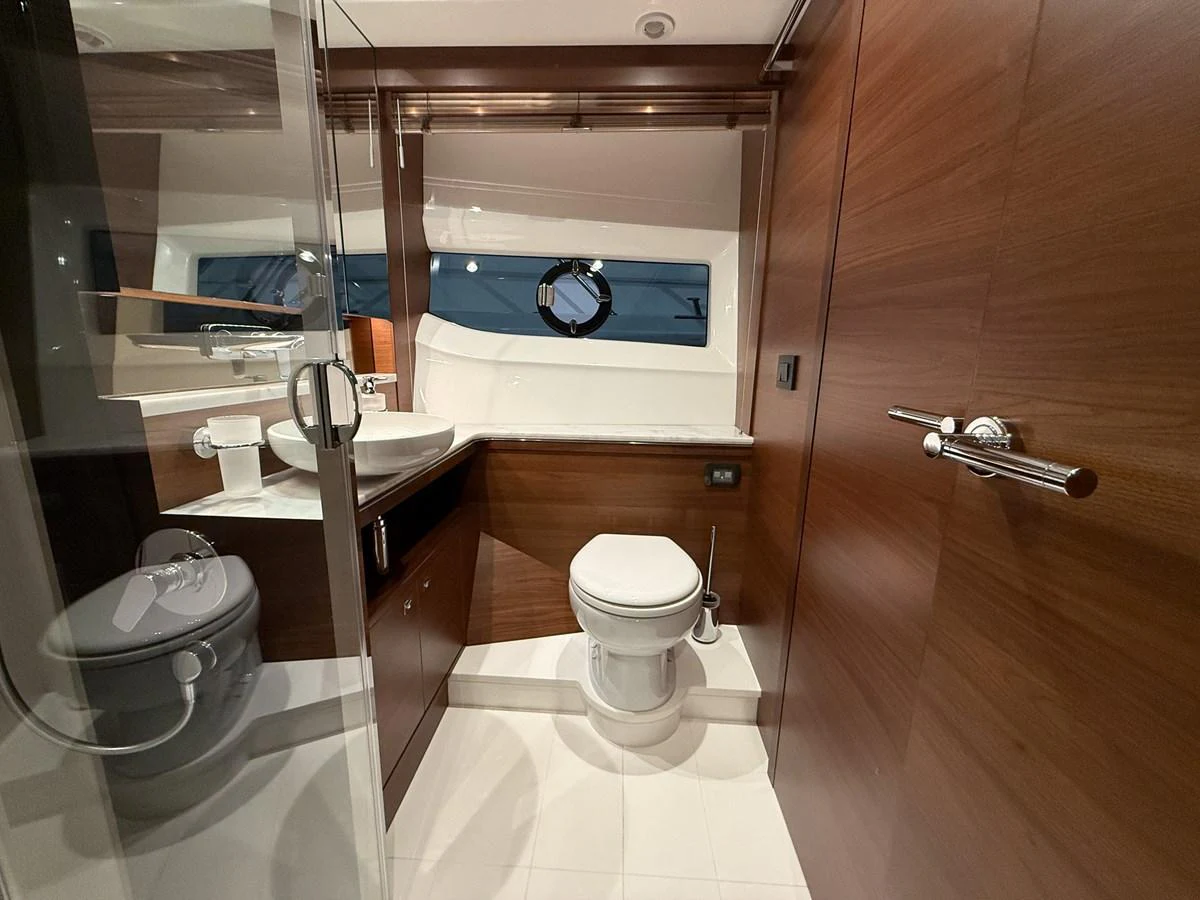 The yacht's bathroom features modern fixtures and elegant wood paneling. aboard PRINCESS 70 Yacht for Sale