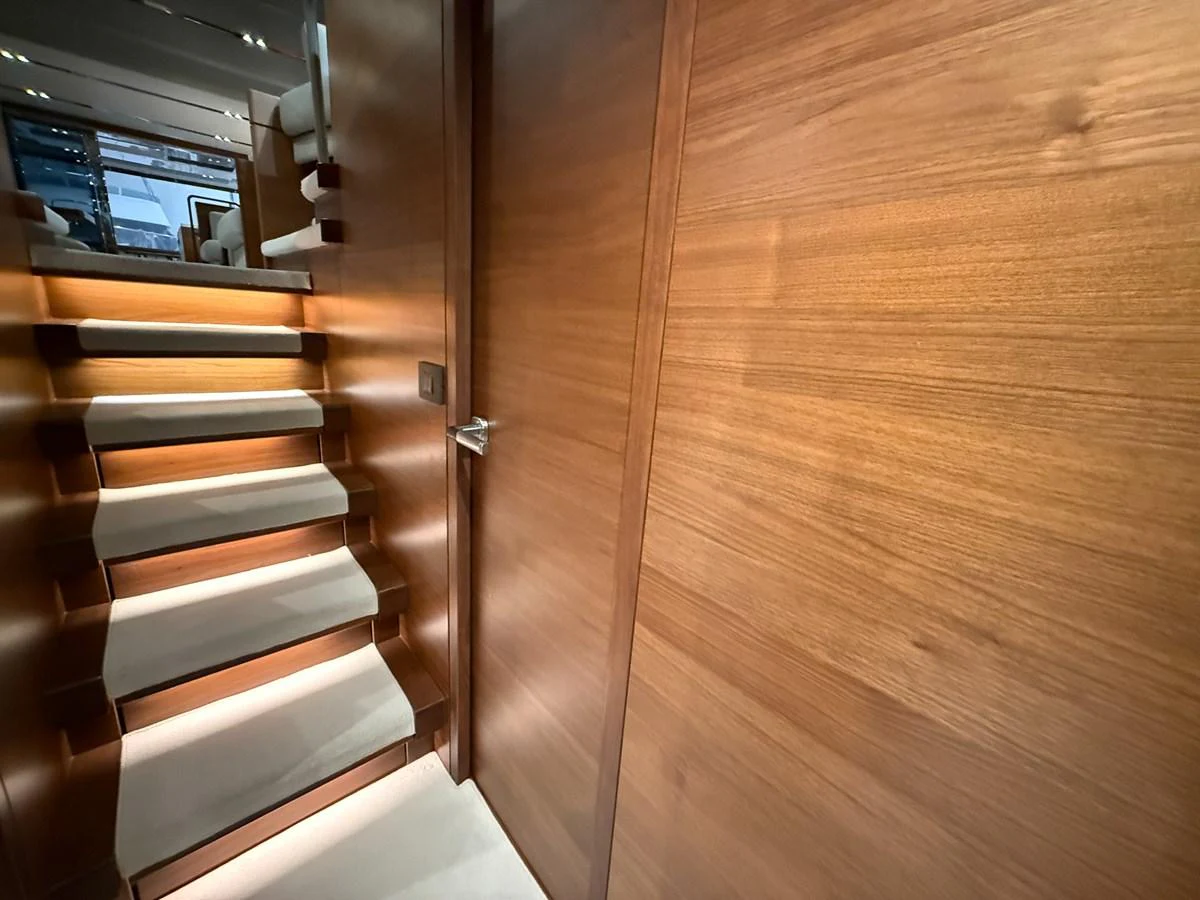 A beautifully crafted wooden staircase with soft lighting leads to the upper deck. aboard PRINCESS 70 Yacht for Sale