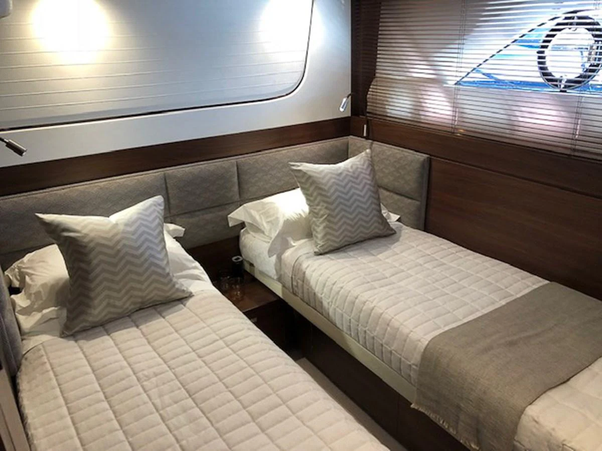 The guest cabin features twin beds with plush bedding and modern decor. aboard PRINCESS 70 Yacht for Sale