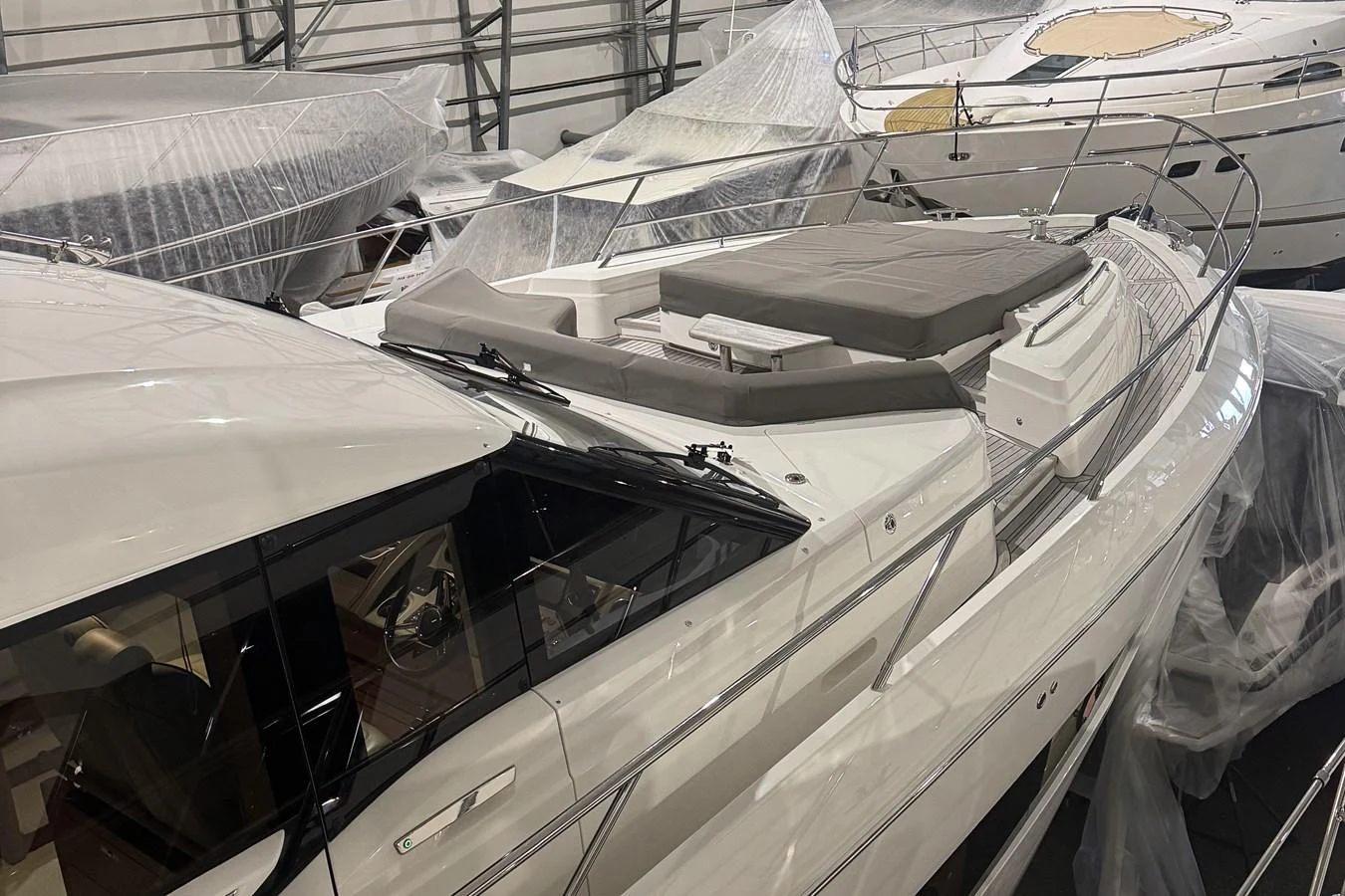 The yacht is stored indoors, surrounded by other vessels and protective covers. aboard PRINCESS 70 Yacht for Sale