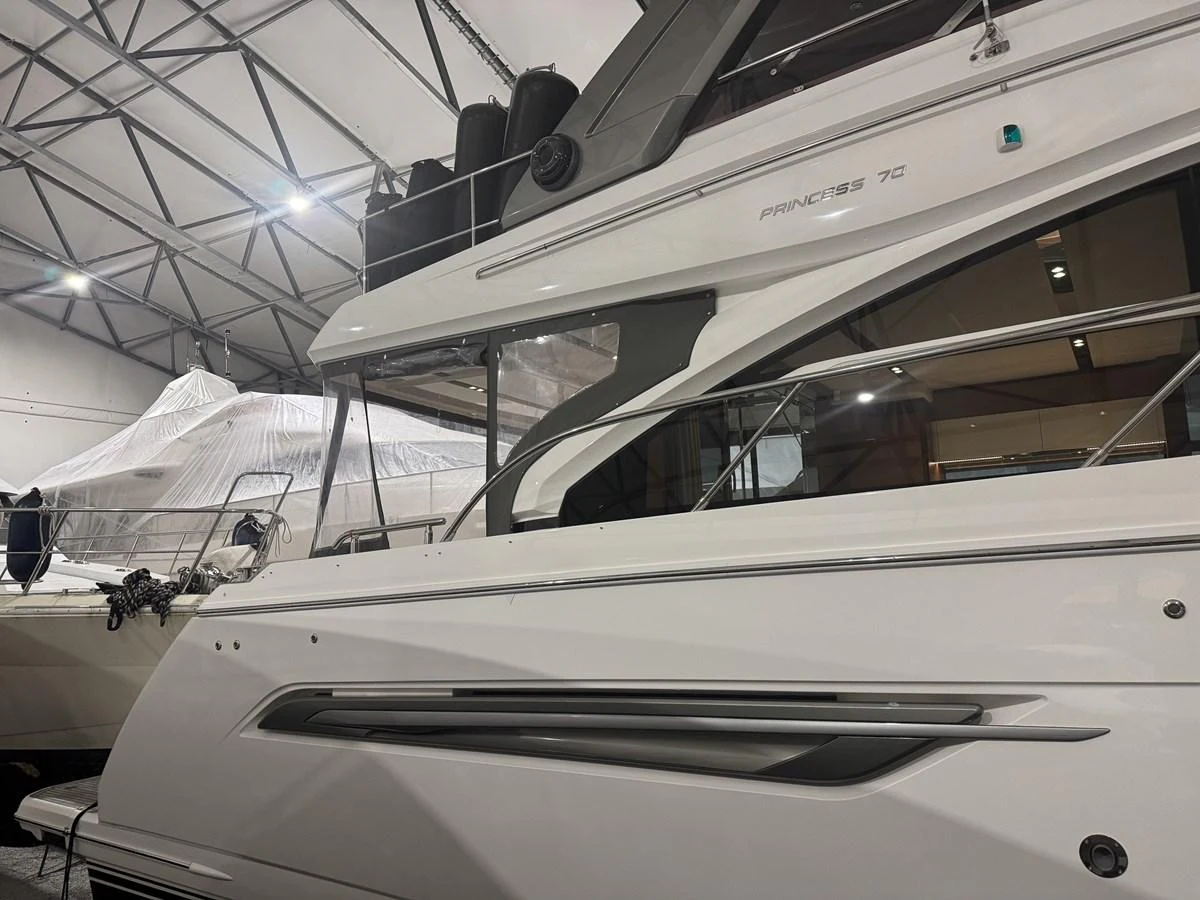 The yacht is showcased in an indoor setting, highlighting its sleek exterior lines and modern design. aboard PRINCESS 70 Yacht for Sale