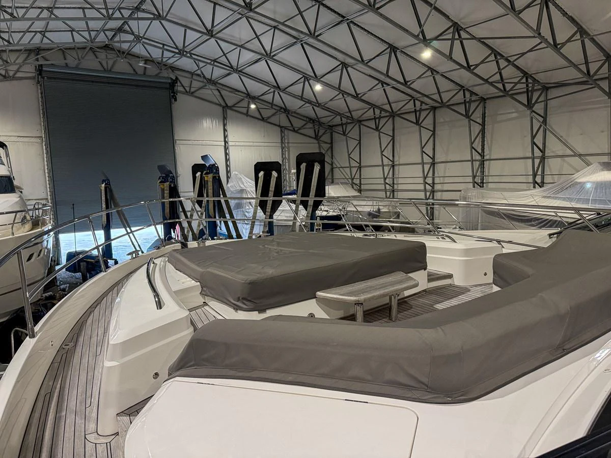 The yacht's sundeck features spacious lounging areas with comfortable cushions, situated in a covered storage facility. aboard PRINCESS 70 Yacht for Sale