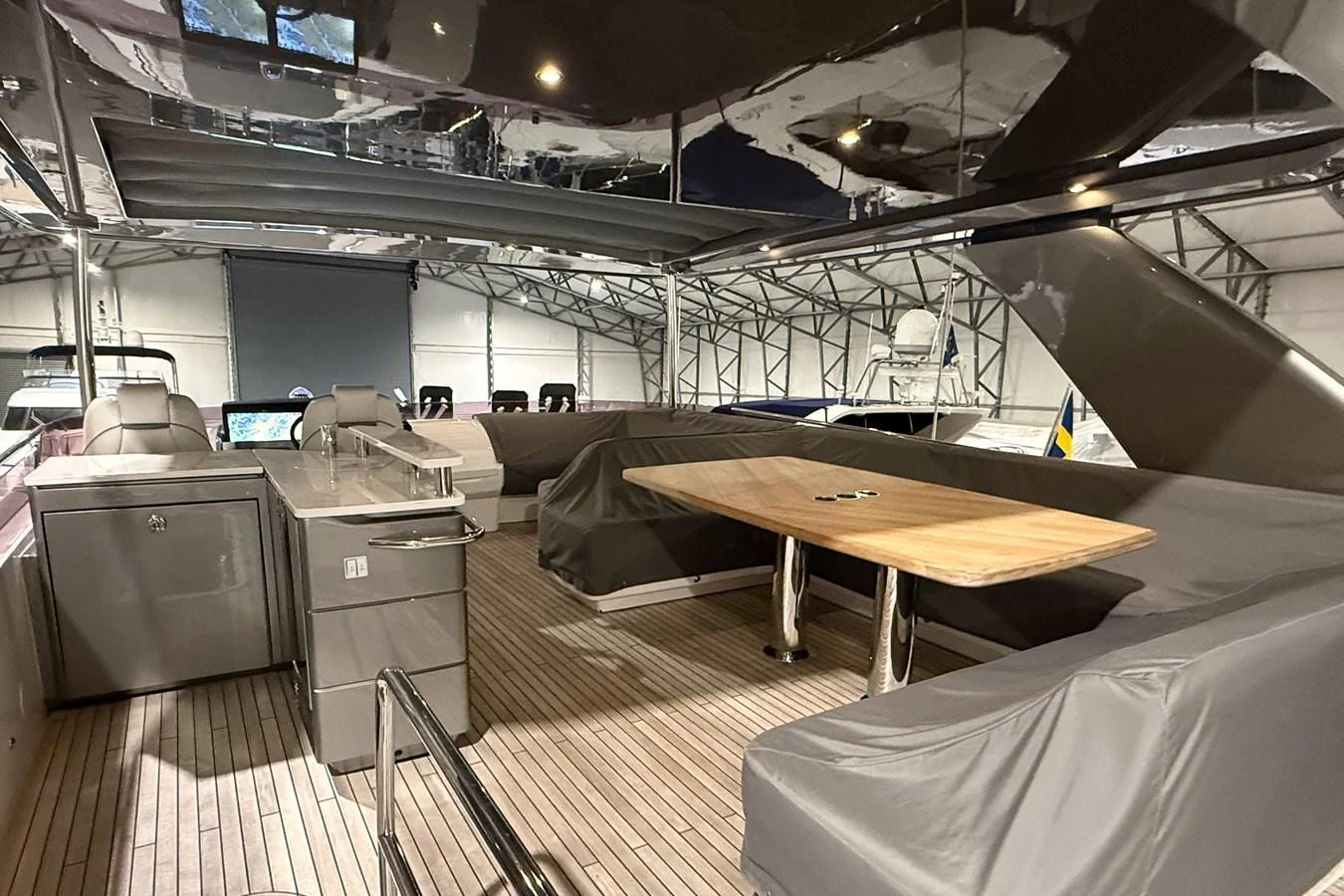 The sundeck features a spacious seating area with a wooden table, perfect for outdoor dining and relaxation. aboard PRINCESS 70 Yacht for Sale