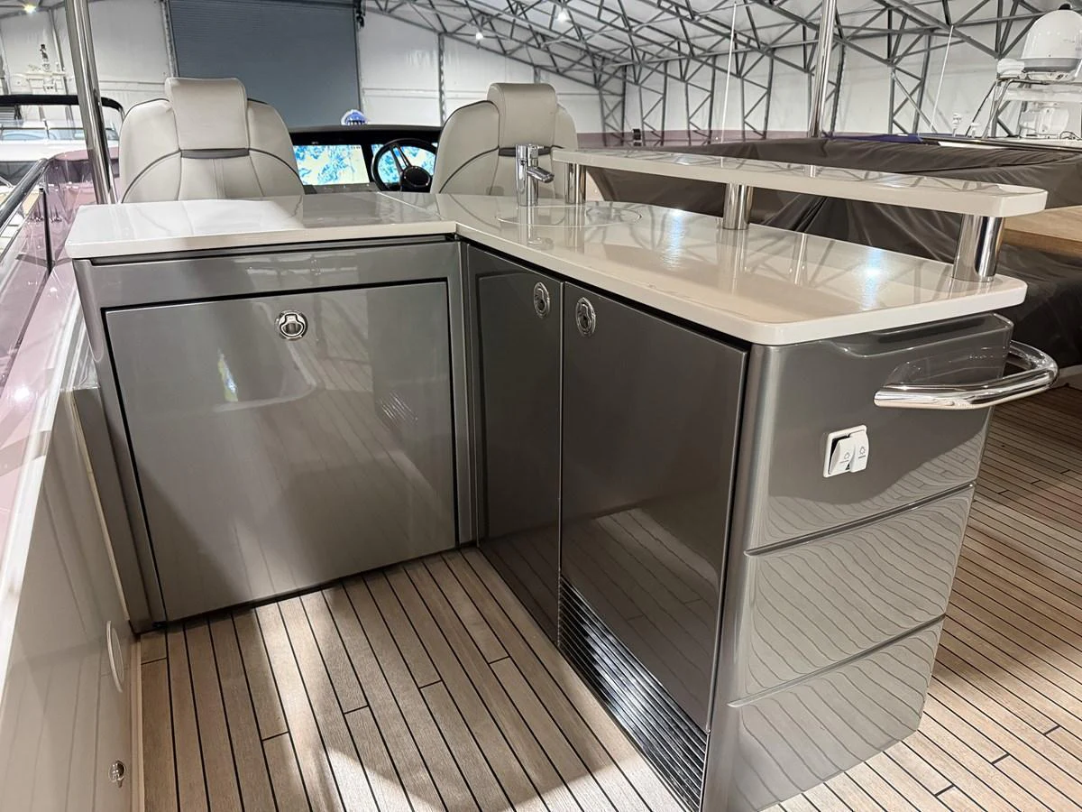 A sleek and modern yacht galley with high-gloss cabinetry and a polished countertop. aboard PRINCESS 70 Yacht for Sale