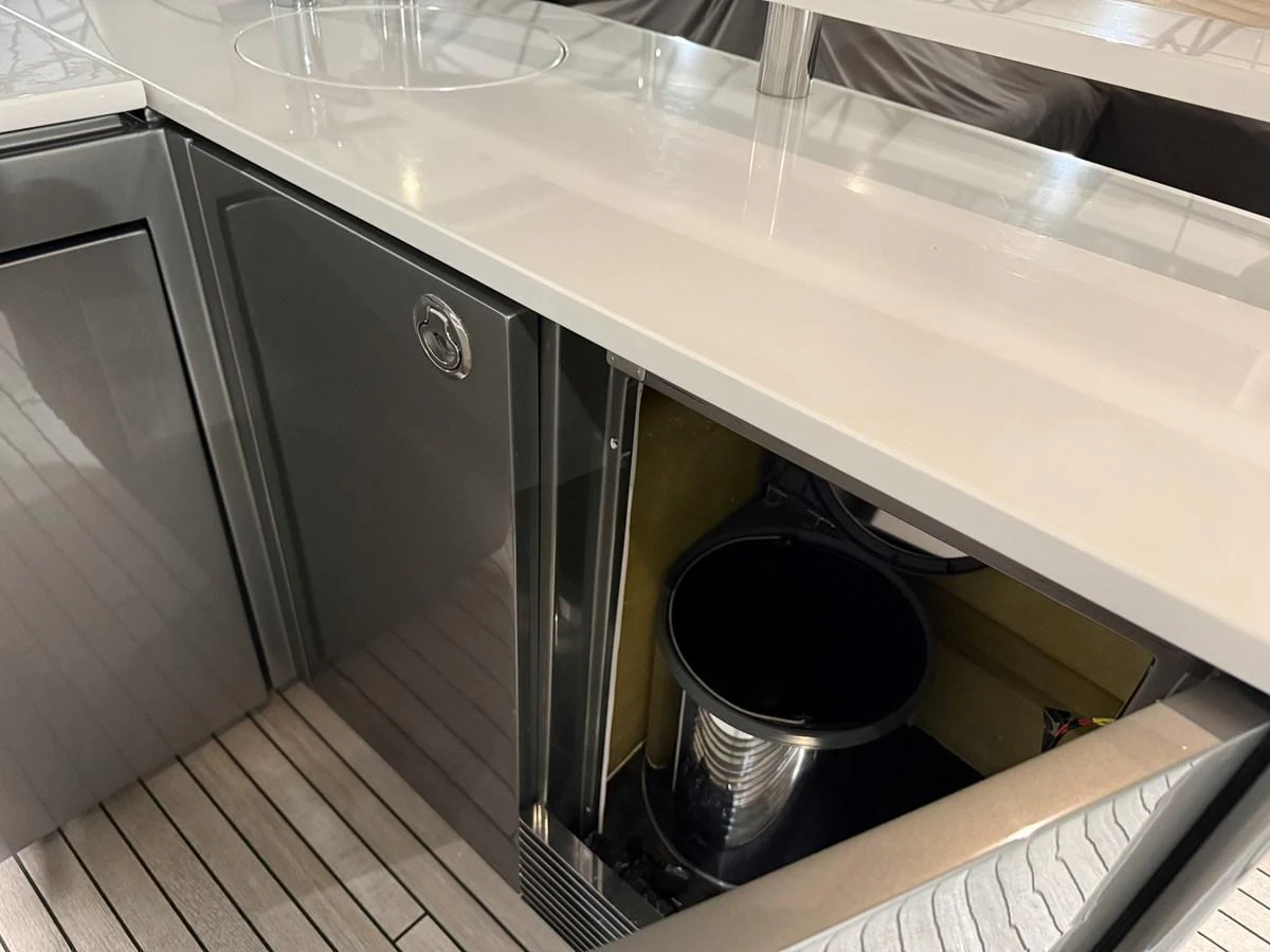 A sleek and modern galley area featuring a built-in trash bin and polished surfaces. aboard PRINCESS 70 Yacht for Sale