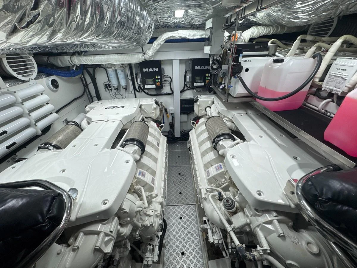 The image showcases the yacht's pristine engine room with dual engines and well-organized equipment. aboard PRINCESS 70 Yacht for Sale