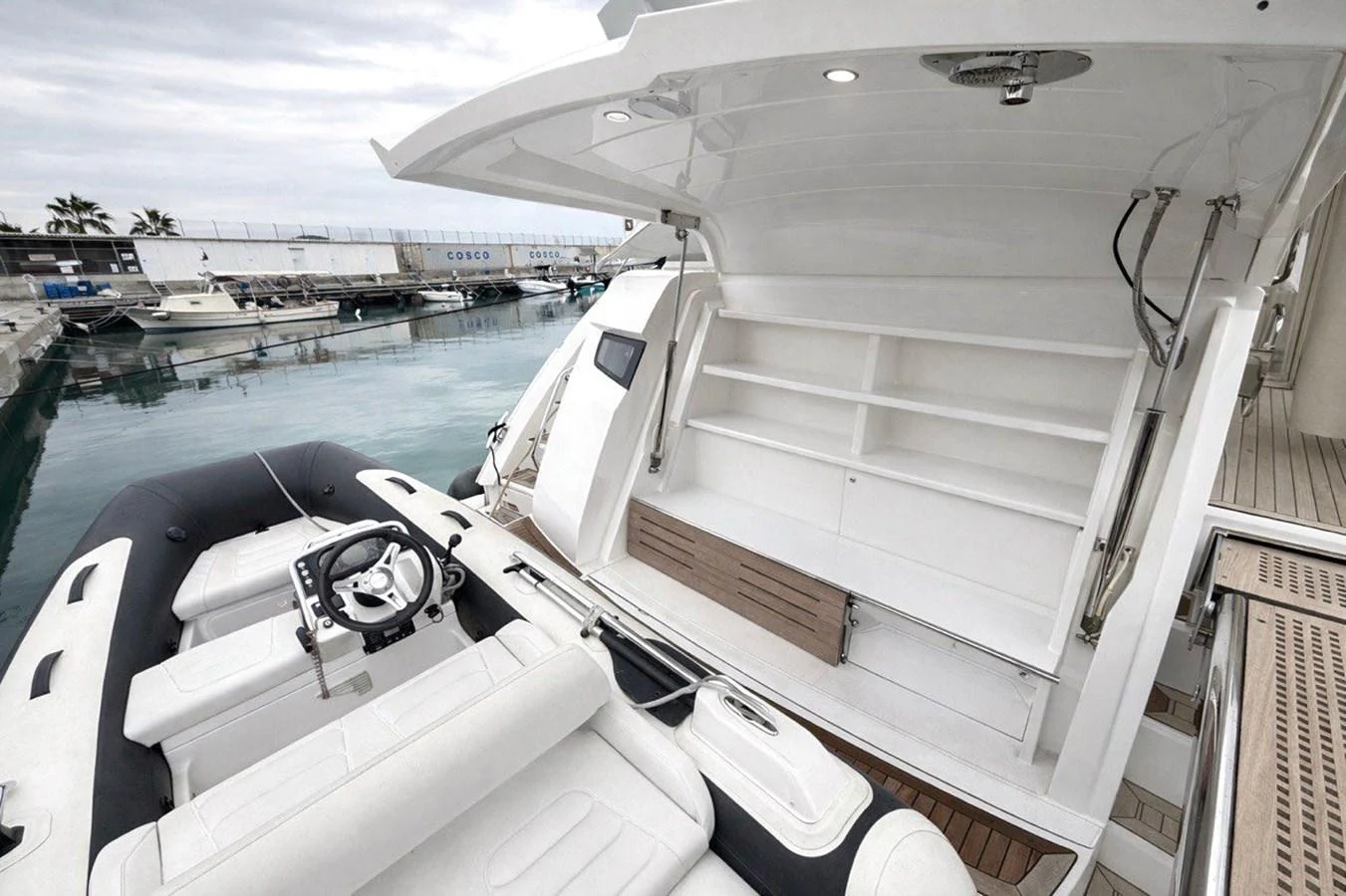 The image showcases a tender boat docked at the stern of a yacht, highlighting the spacious and well-equipped boarding area. aboard SUNSEEKER 66 MANHATTAN Yacht for Sale