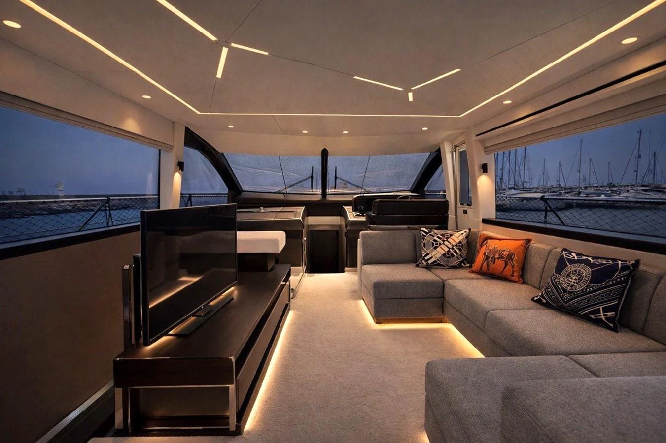 The salon features modern furnishings with ambient lighting and panoramic windows offering a serene view of the marina. aboard SUNSEEKER 66 MANHATTAN Yacht for Sale