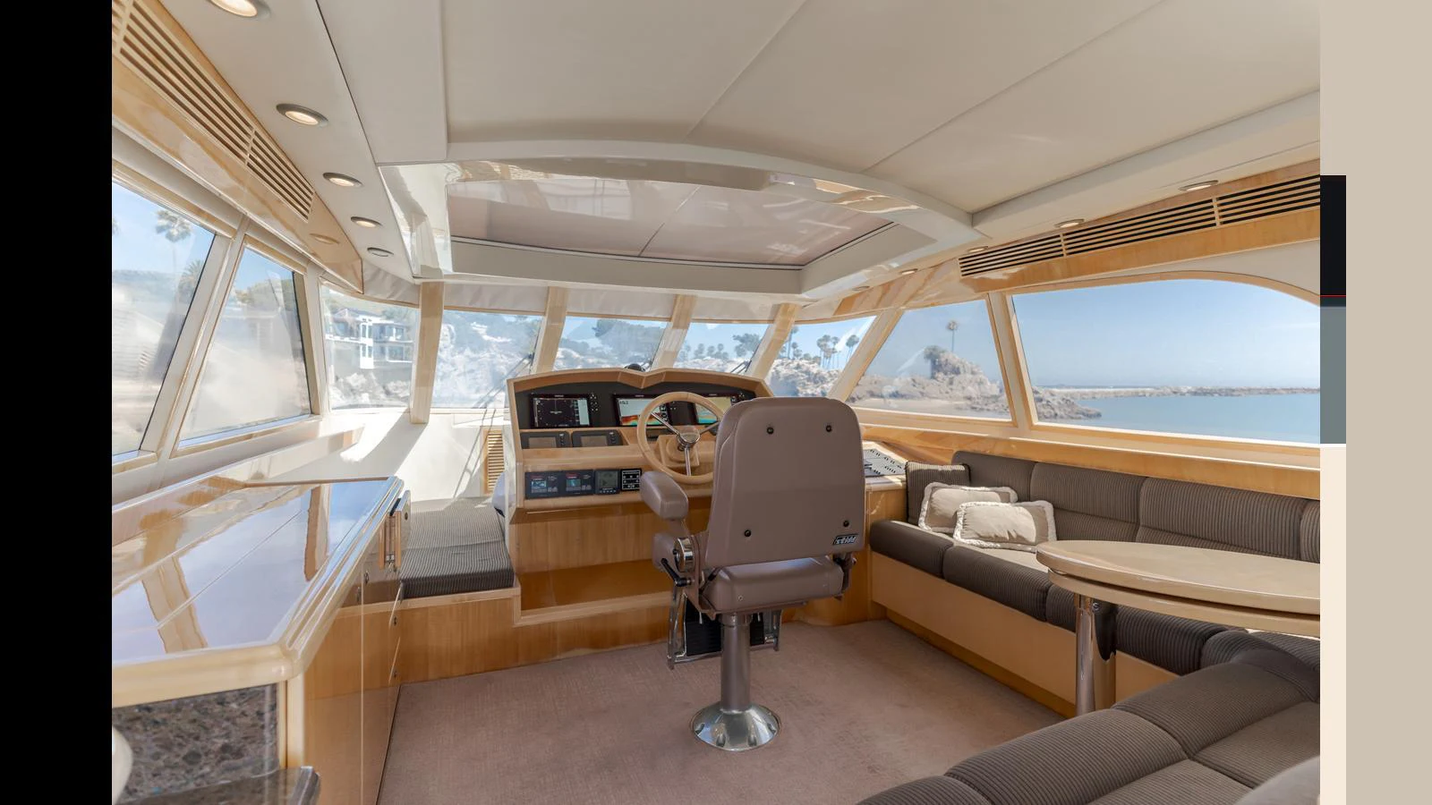 The helm area features a spacious and luxurious design with panoramic windows offering stunning views. aboard SEAQUEL Yacht for Sale
