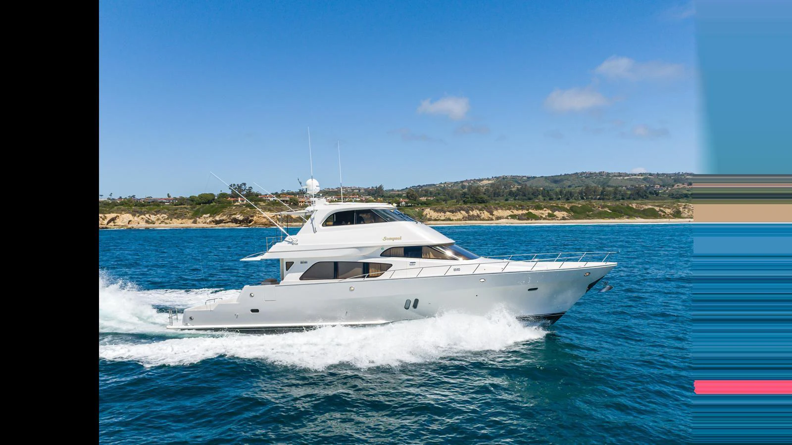 A sleek yacht cruises through clear blue waters against a scenic coastal backdrop. aboard SEAQUEL Yacht for Sale