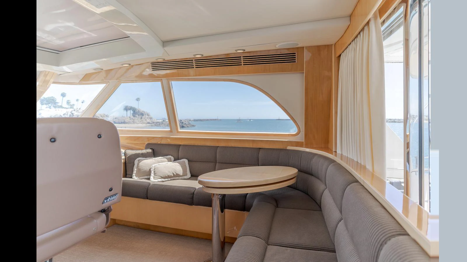 The salon features a cozy seating area with a round table and large windows offering stunning sea views. aboard SEAQUEL Yacht for Sale