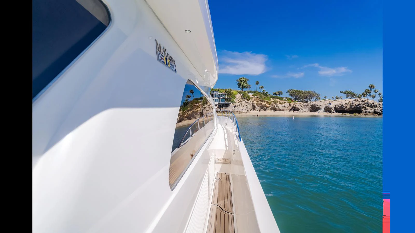 A sleek yacht cruising along a picturesque coastline with clear blue skies. aboard SEAQUEL Yacht for Sale
