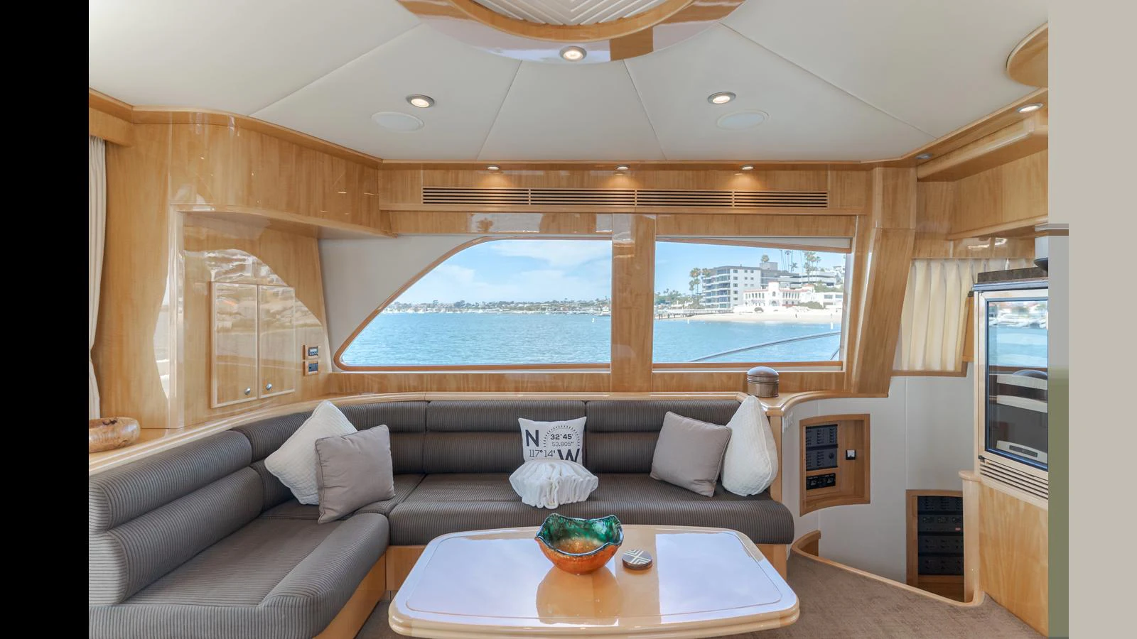 The salon features plush seating with large windows offering a scenic view of the water. aboard SEAQUEL Yacht for Sale
