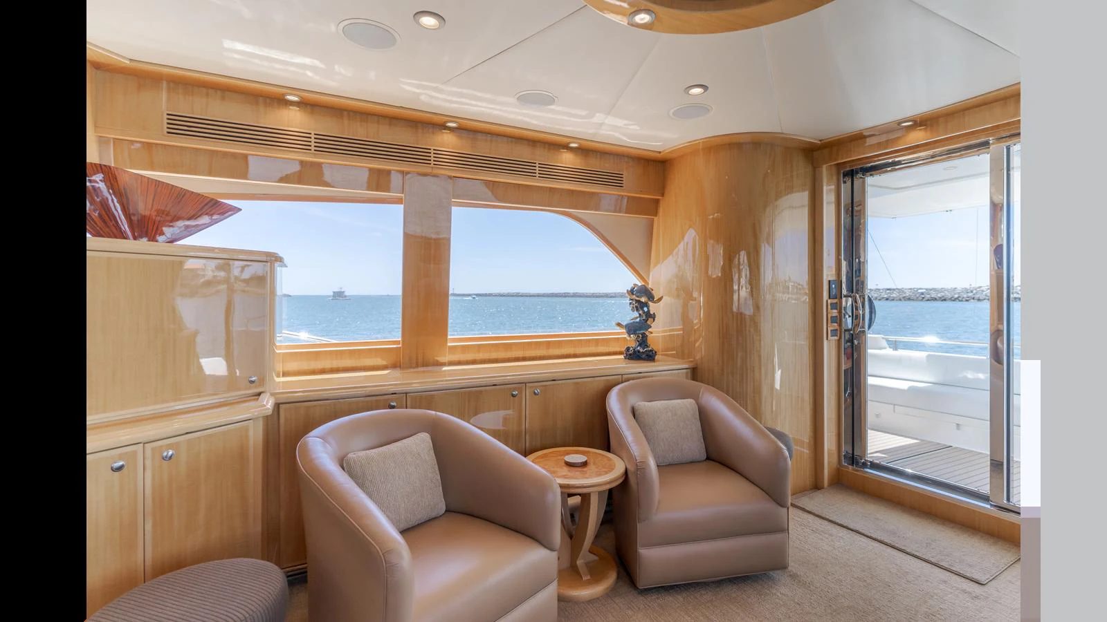 The yacht's interior features a cozy seating area with large windows offering stunning ocean views. aboard SEAQUEL Yacht for Sale