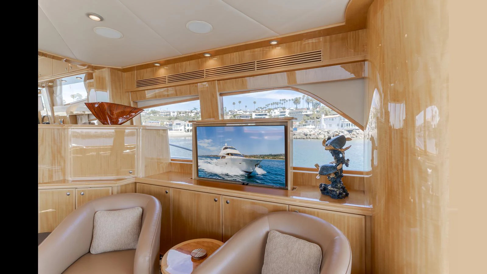 The salon features plush seating and a large window with a view of the marina. aboard SEAQUEL Yacht for Sale