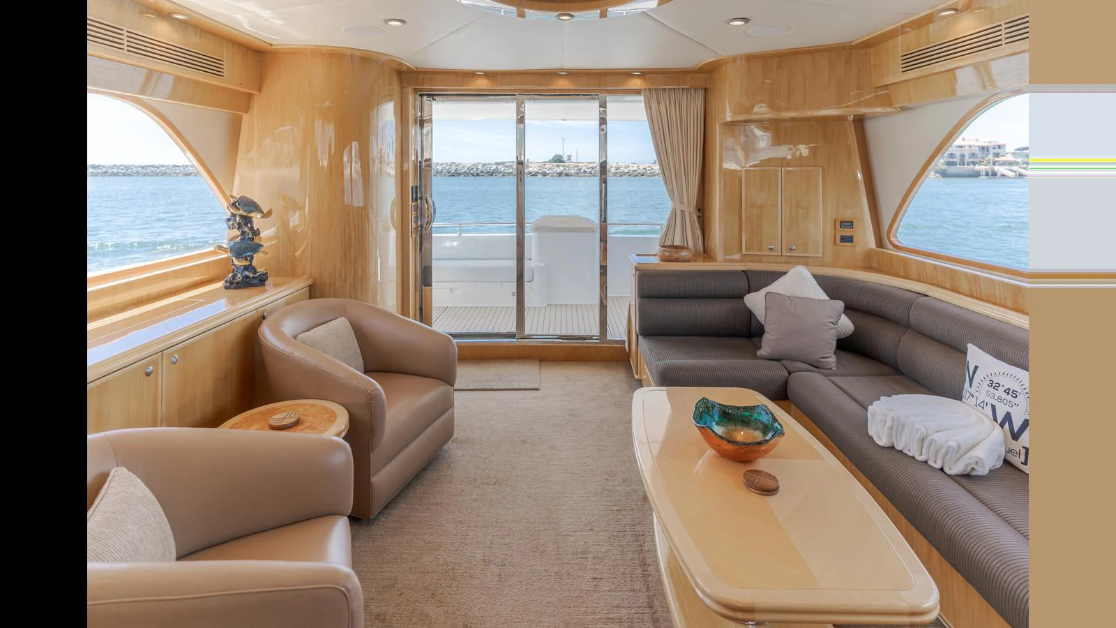 The salon features plush seating, a coffee table, and large windows offering stunning ocean views. aboard SEAQUEL Yacht for Sale