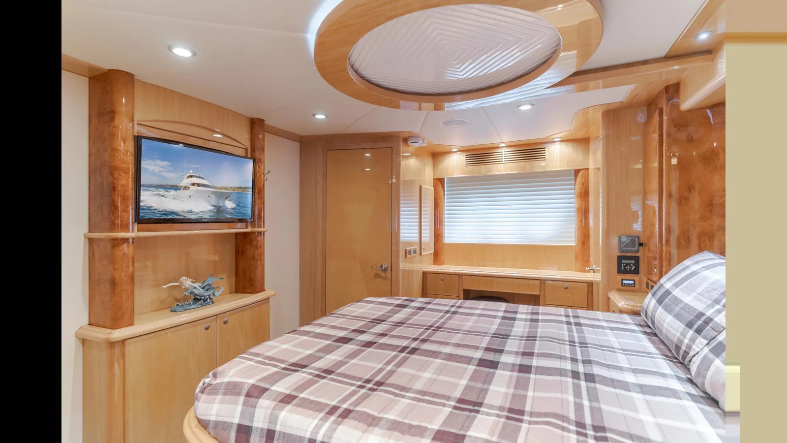 The stateroom features a comfortable bed, a flat-screen TV, and elegant wood finishes. aboard SEAQUEL Yacht for Sale