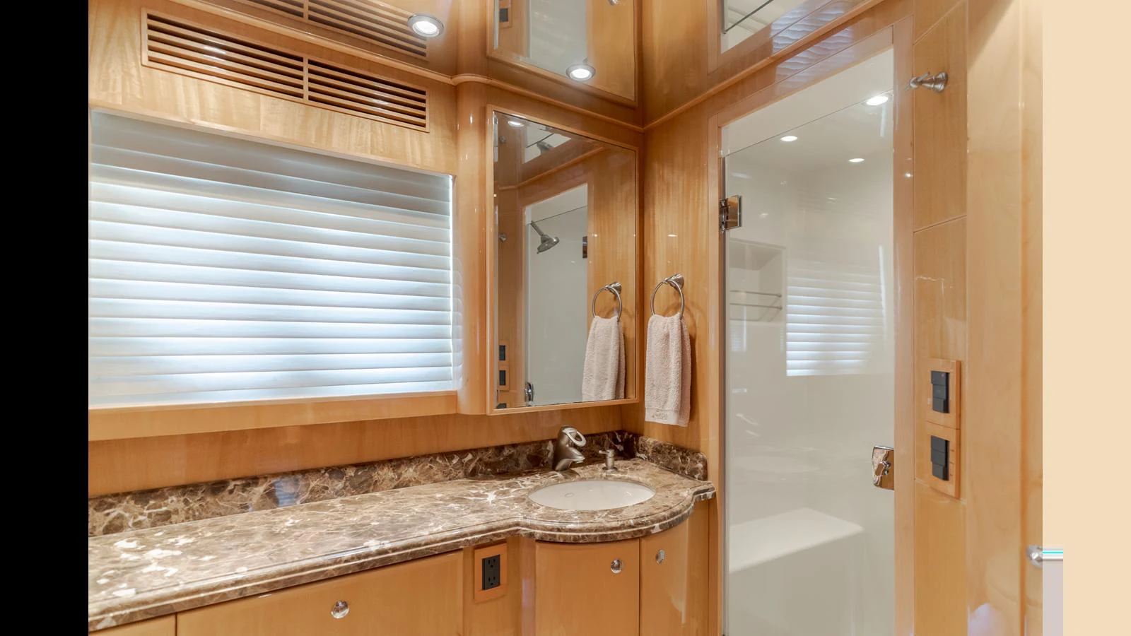 The yacht's bathroom features elegant wood paneling and a marble countertop, creating a luxurious and serene atmosphere. aboard SEAQUEL Yacht for Sale