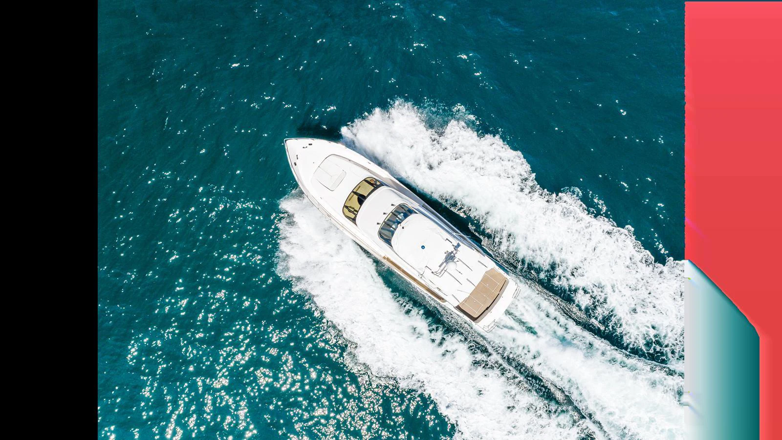 A sleek yacht cruises swiftly through vibrant blue waters, leaving a trail of white foam in its wake. aboard SEAQUEL Yacht for Sale