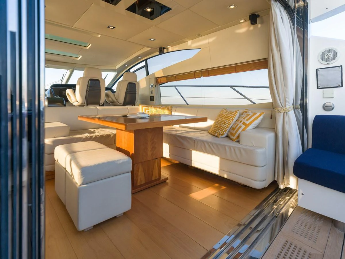 The salon features a comfortable seating area with a wooden table and ample natural light. aboard M/Y MIEL Yacht for Sale