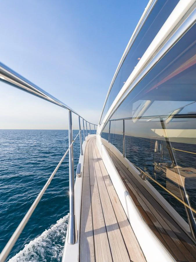 A sleek yacht glides smoothly over the water, showcasing its elegant side deck and modern design. aboard M/Y MIEL Yacht for Sale